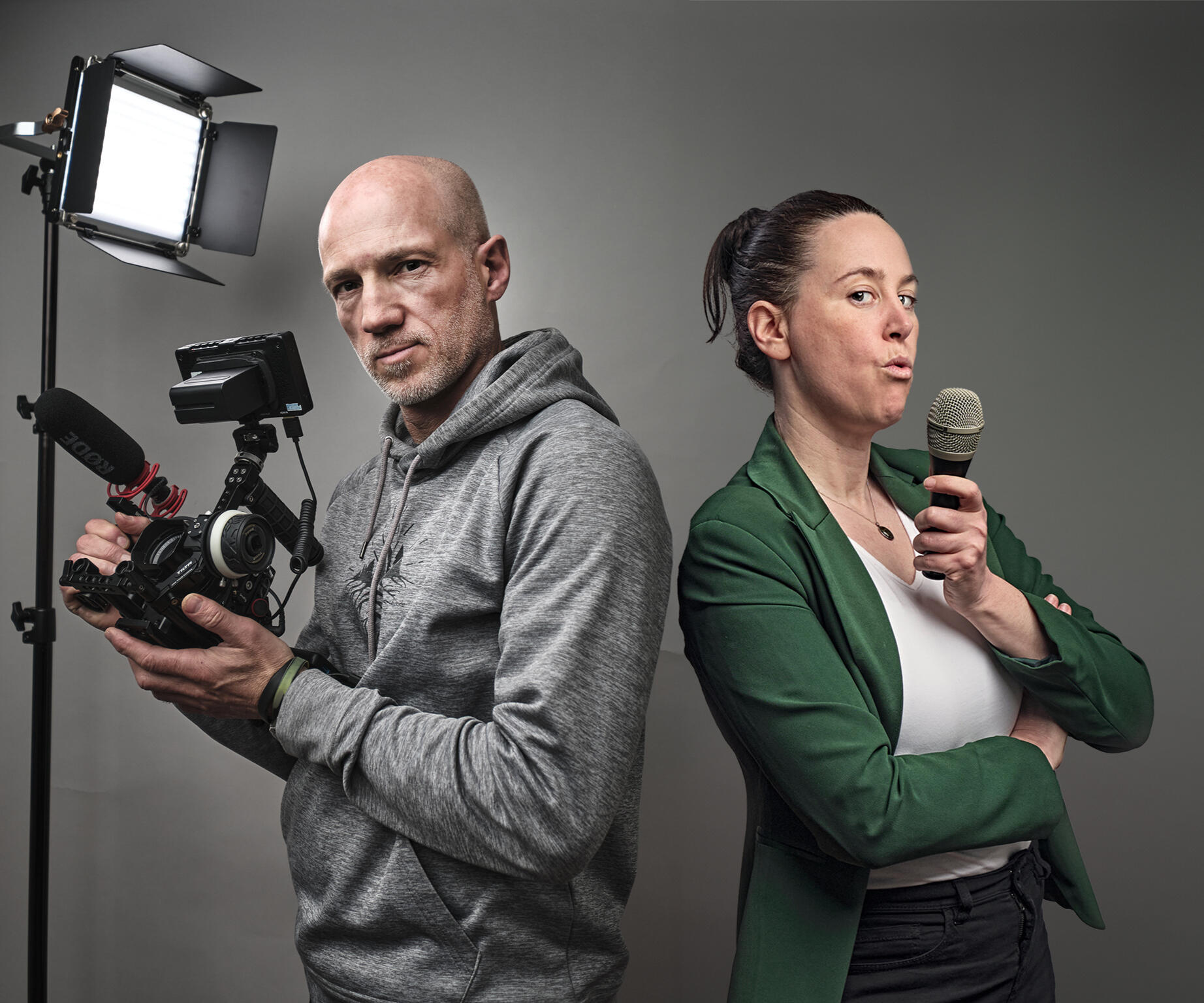 Alex Harris and Sarah Martens blowing imaginary smoke from their camera and microphone as if from smoking guns.